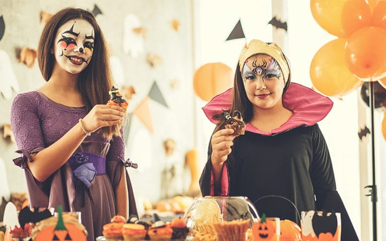 Teenagers toasting in costumes on Halloween