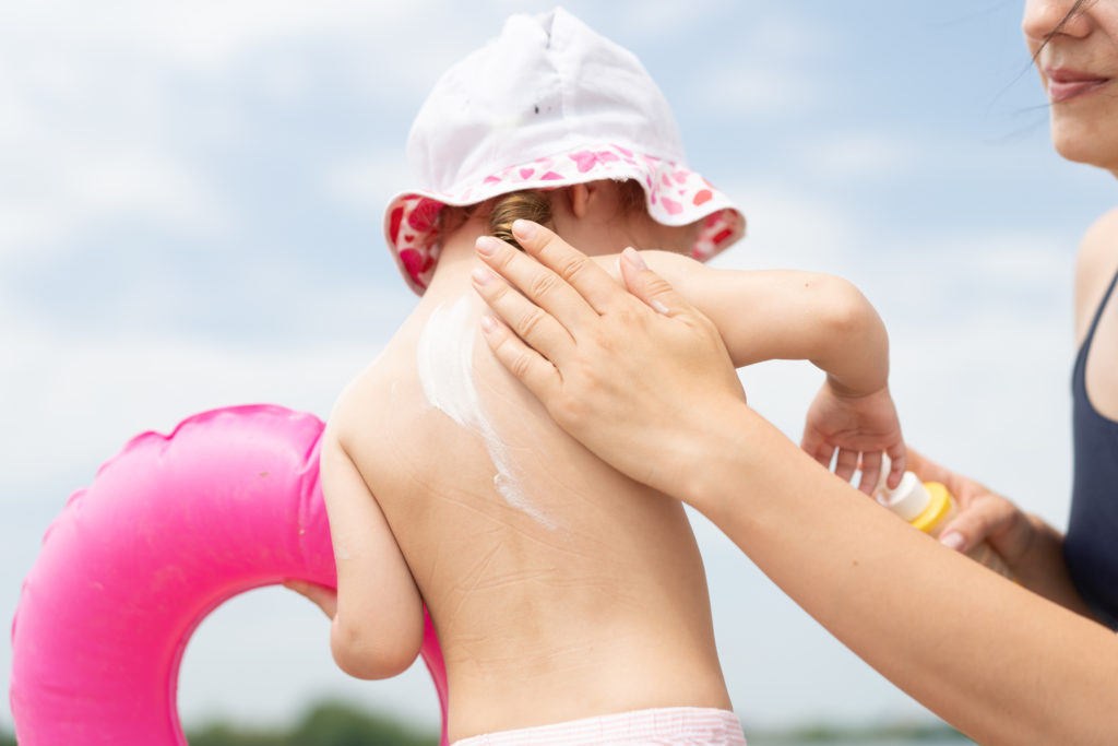 mom putting sunscreen on child