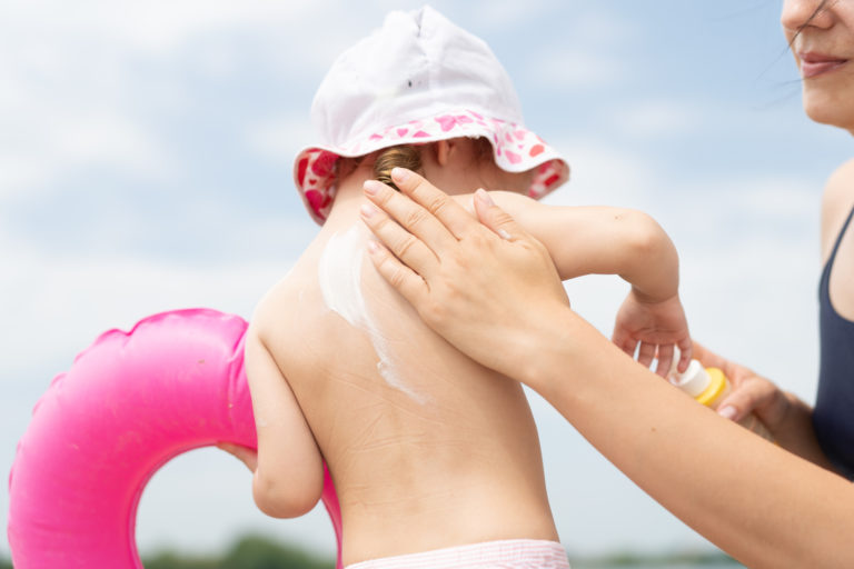 mom putting sunscreen on child