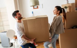 young man and woman moving a box together