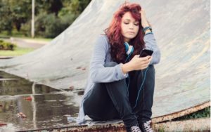 teenager texting at skate park