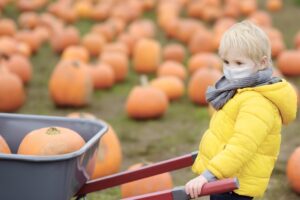 little boy wearing face mask at pumpkin patch