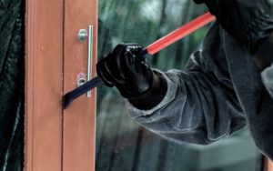 thief entering home with a crowbar