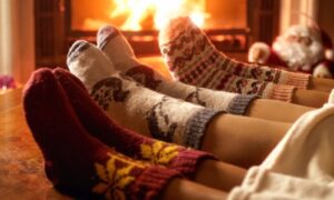 closeup photo of family wearing wool socks in front of a fireplace