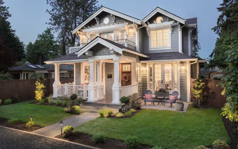 Large craftsman style house at twilight with lights on