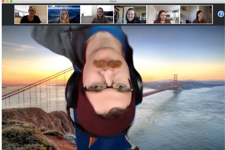 Zoom screenshot of upside down man in front of Golden Gate Bridge background