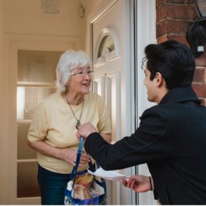 man delivering groceries to old woman