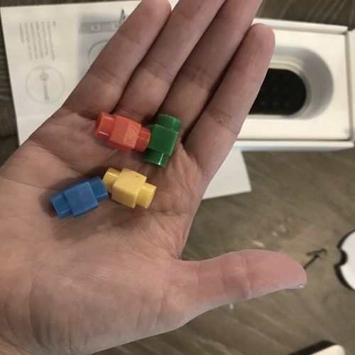 colorful simplisafe lock adapters in the palm of a hand