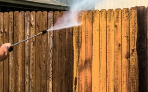 cleaning wooden fence with sprayer