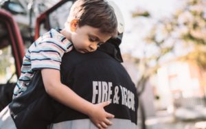 fire fighter holding little boy