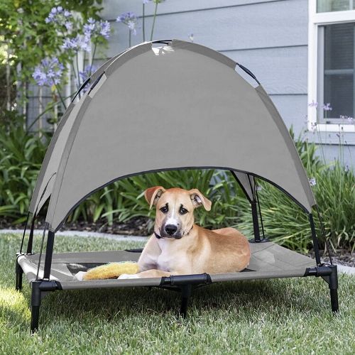 dog resting on pet bed with canopy on the lawn
