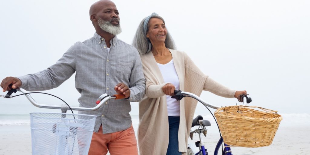 older couple on the beach with bicycles