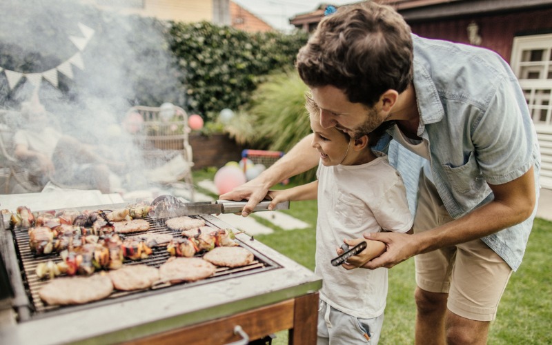 father and son grilling meat