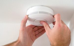 man installing smoke detector