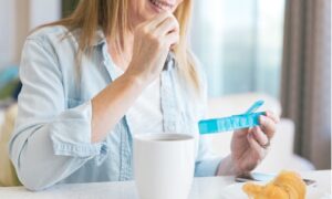 Woman taking medication with breakfast