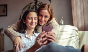 mother and daughter looking at smartphone
