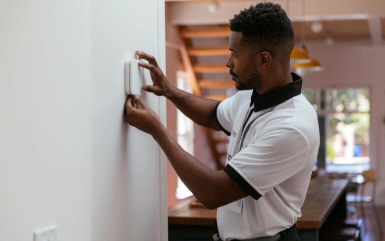 man installing Vivint smart thermostat