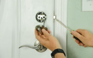 person installing a deadbolt lock