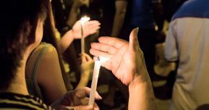 People holding candles at a vigil at night