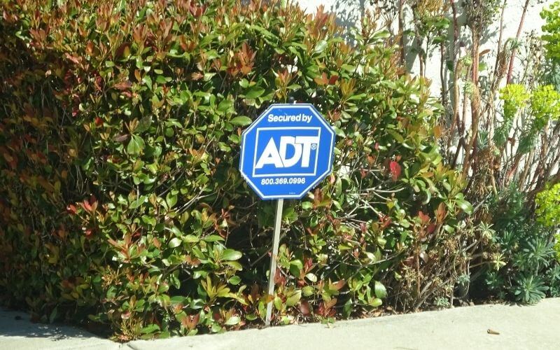 ADT sign in front of hedge