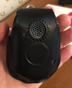 Senior safety expert Cathy Habas holding the Bay Alarm Mobile GPS Unit inside its leather holster to demonstrate its size and appearance.