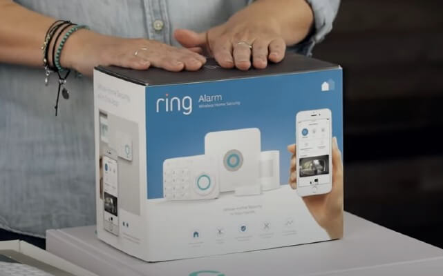 A close-up of home security and safety expert Rebecca Edwards with a 5-piece Ring Alarm home security system still in its box.