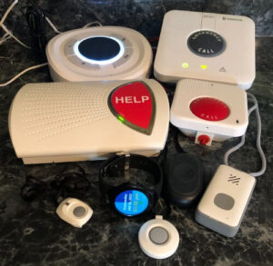 A collection of medical alert systems from different brands arranged on senior safety expert Cathy Habas's kitchen counter, ready for testing.