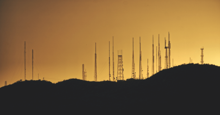 cell towers lined up against the sky