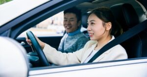 women driving with man in car