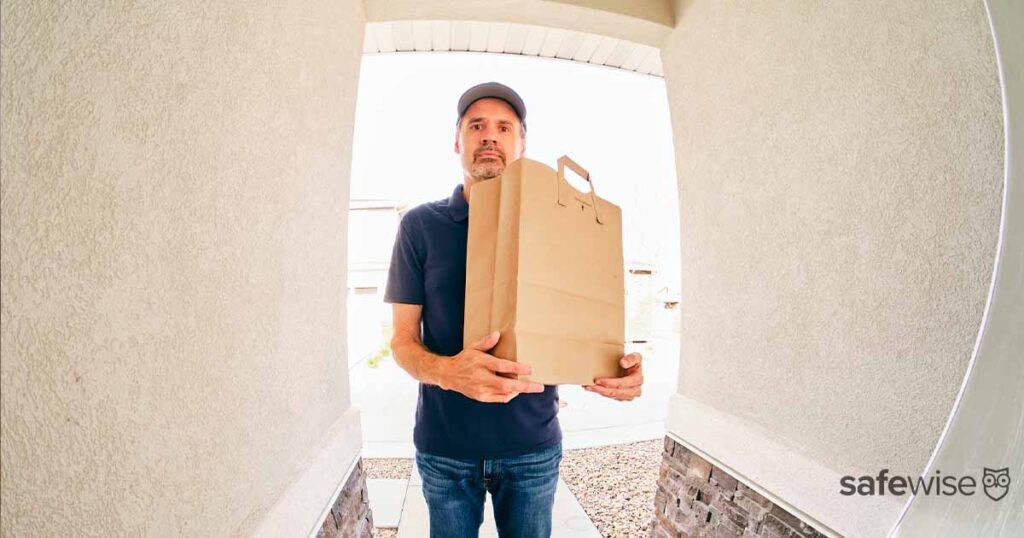 male-holding-grocery-bag-through-doorbell-camera