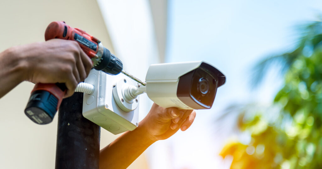 Technician installing IP wireless CCTV camera by screwed for hom