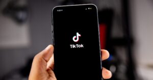 hand holding an iphone with the tiktok app loaded