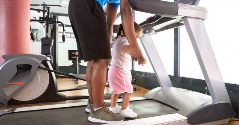 Dad exercising with daughter on treadmill