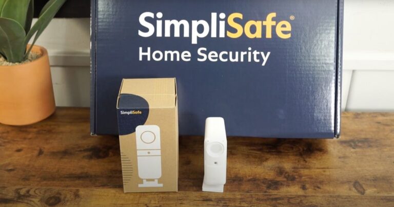 SimpliSafe Smart Alarm Camera on table next to product box and in front of SimpliSafe security system box