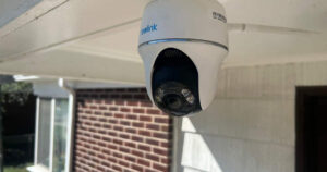 Reolink Argus PT Ultra camera installed on a front porch with brick on the house in the background