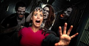 Woman struggles to get away from Zombies in haunted house stock photo