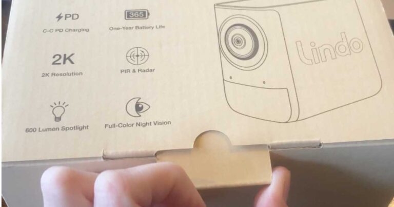 Hand opening the box with the Lindo Spotlight Camera inside.