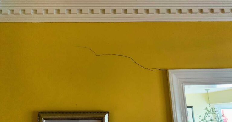 Internal foundation crack on a yellow wall.