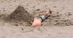 Boy digging a sand hole on the beach.