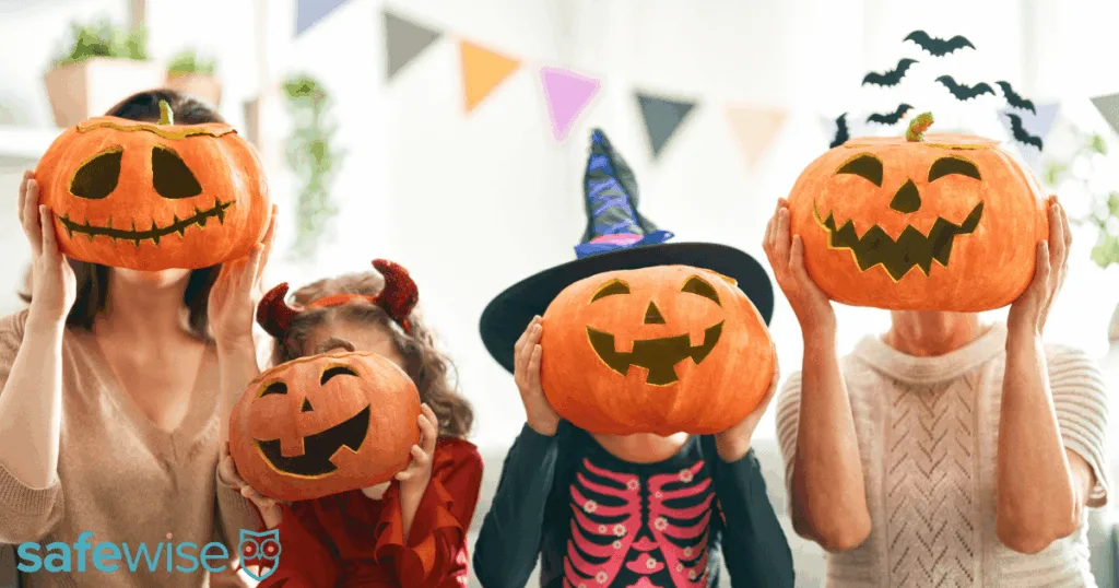 Family holding Jack-o-lanterns in front of their faces.