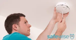 Man installing carbon monoxide detector.