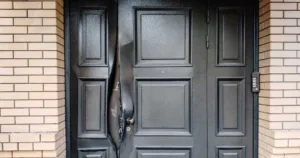 A broken lock on the door of a private brick house