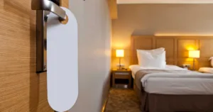 Interior of a hotel room from an open door with a do not disturb sign hanging on the doorknob