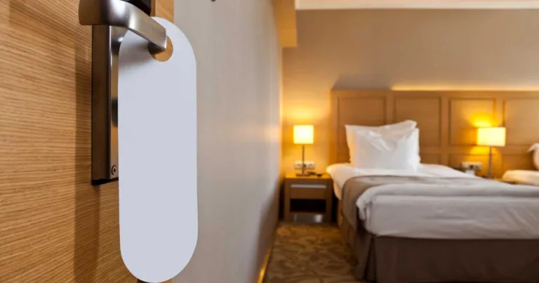 Interior of a hotel room from an open door with a do not disturb sign hanging on the doorknob
