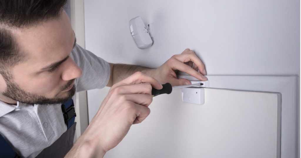 Installer setting up door sensor