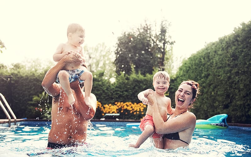 mom, dad, and kids playing together in pool