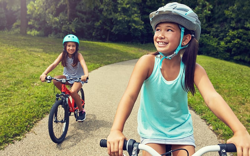 photo of kids with helmets on bikes